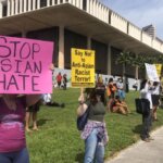 Crowd rallies in front of the Hawaiʻi State Capitol with signs against Anti-Asian sentiments.