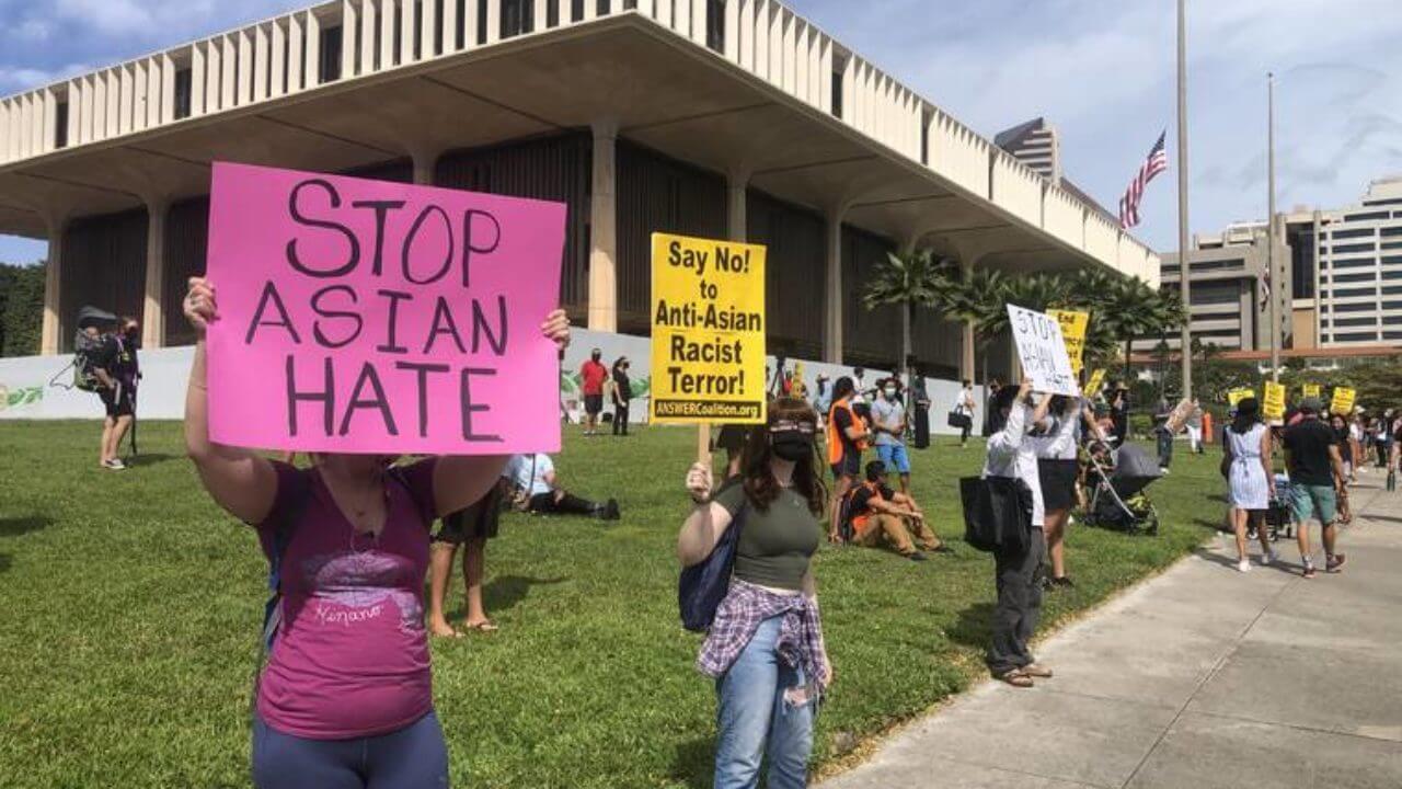 Crowd rallies in front of the Hawaiʻi State Capitol with signs against Anti-Asian sentiments.